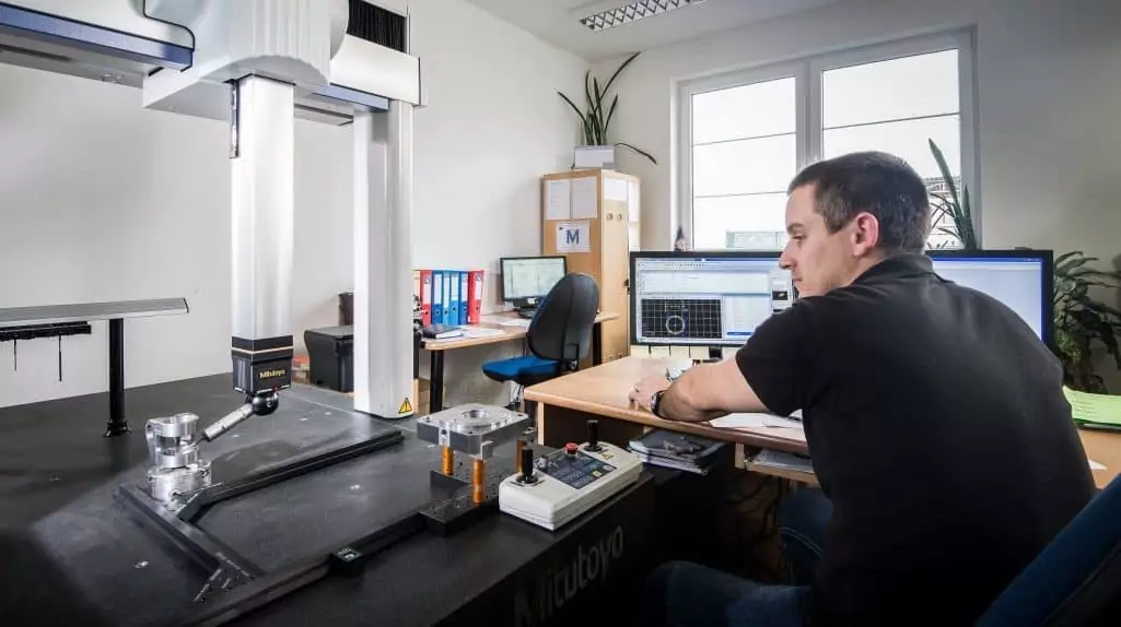 man measuring aluminium part using coordinate measuring machine (CMM)