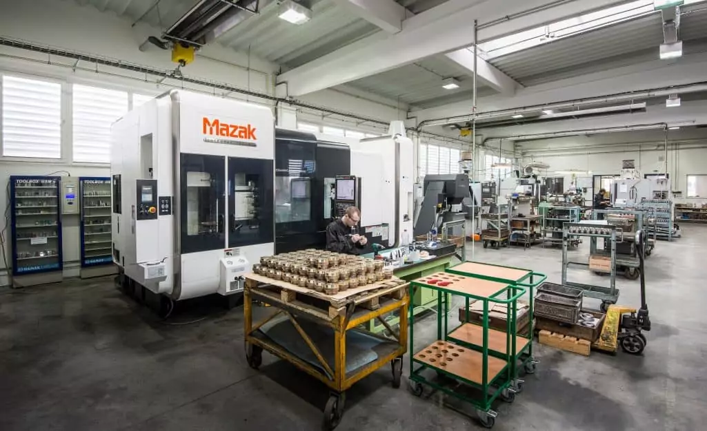 Mazak 5 axis cnc machine in a factory with a man inspecting parts