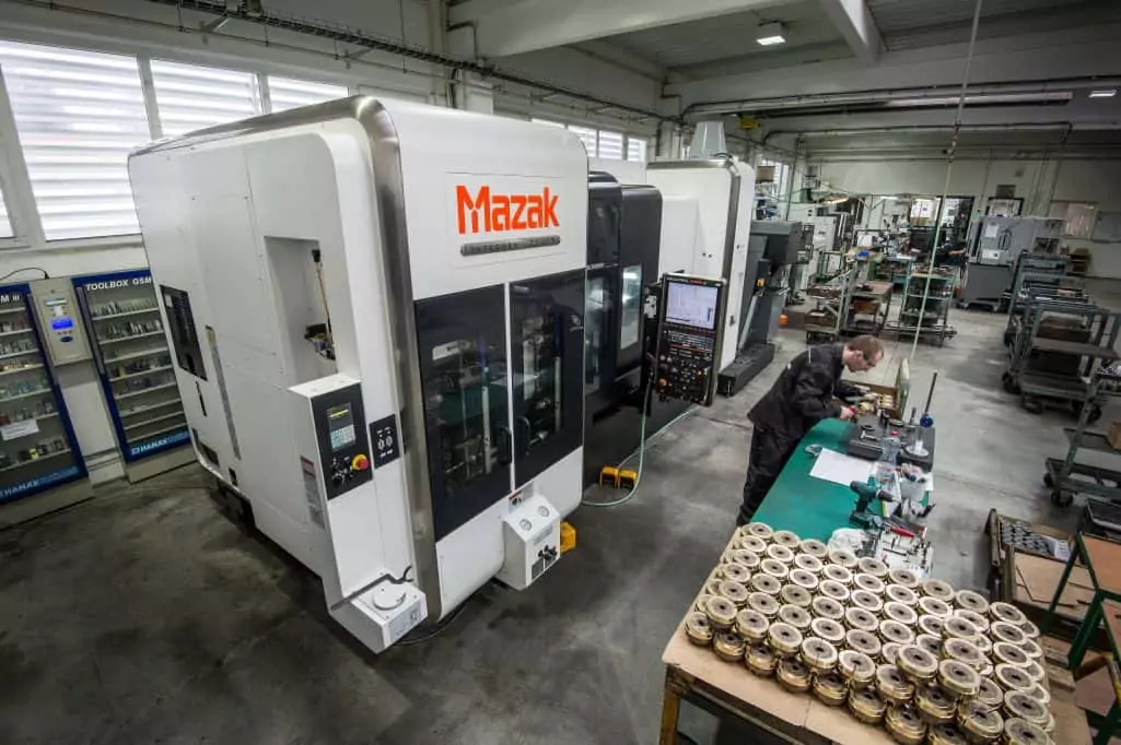 overhead view of mazak 5 axis cnc machining centre and high precision parts on a table in a factory