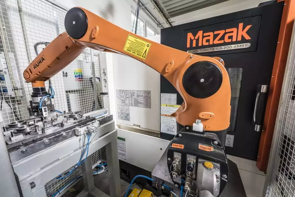 kuka robotic arm loading a cnc machine with an aluminium part