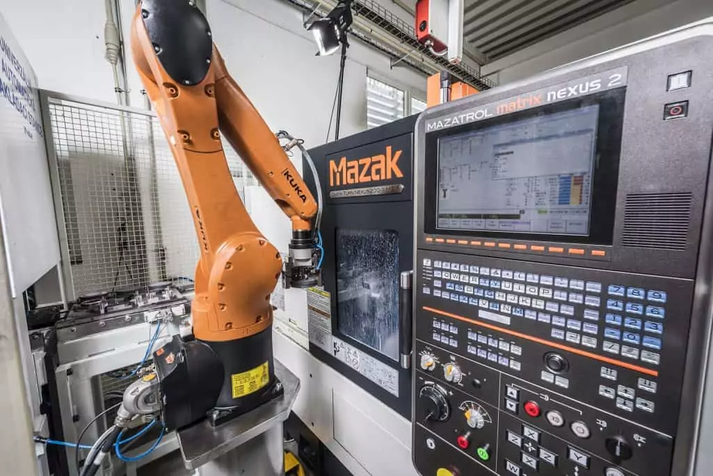 kuka robotic arm unloading a mazak cnc machine with an aluminium part in factory